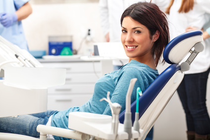 בחורה יושבת על כסא אצל רופא שיניים
