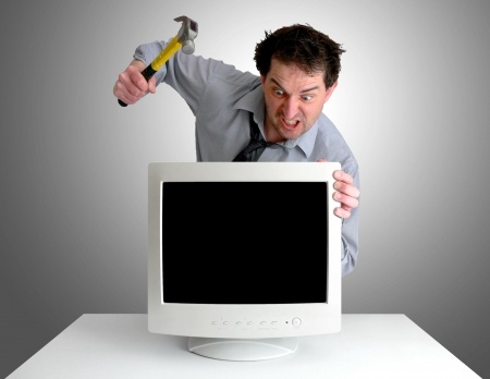 איש מנסה לשבור את המחשב עם פטיש